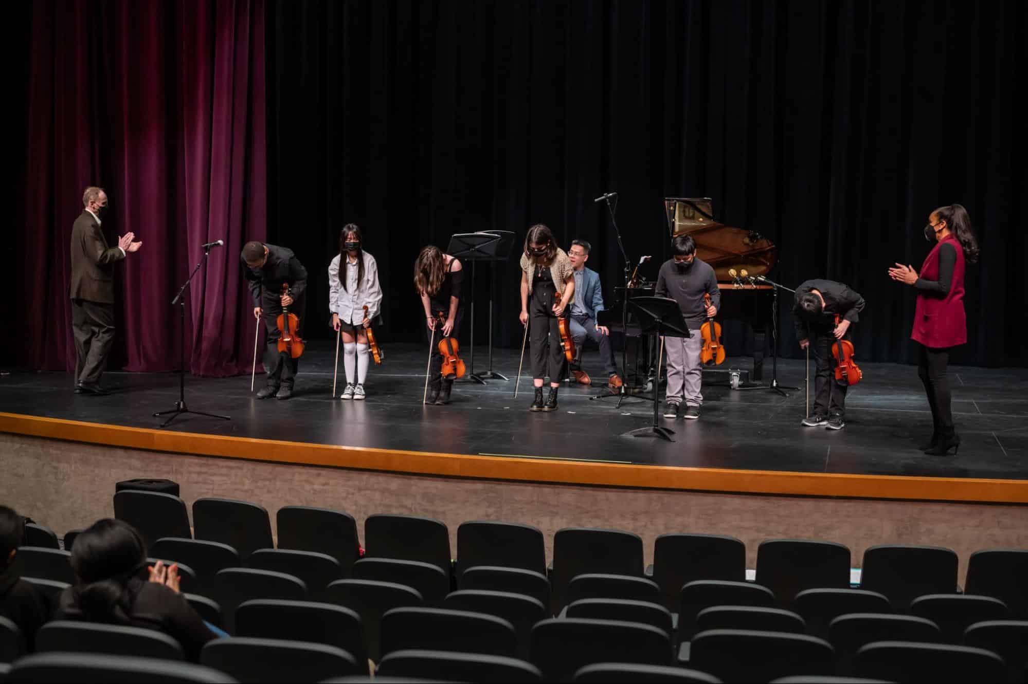 Students bow after a performance