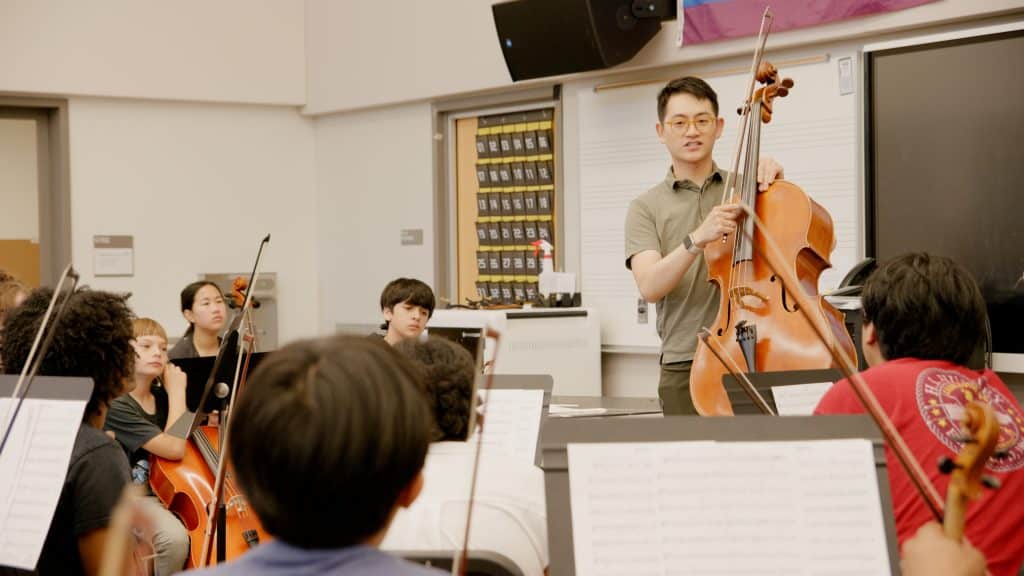 Nathan Chan, Assistant Principal Cellist of the Seattle Symphony gives feedback to students during an orchestra workshop clinic.