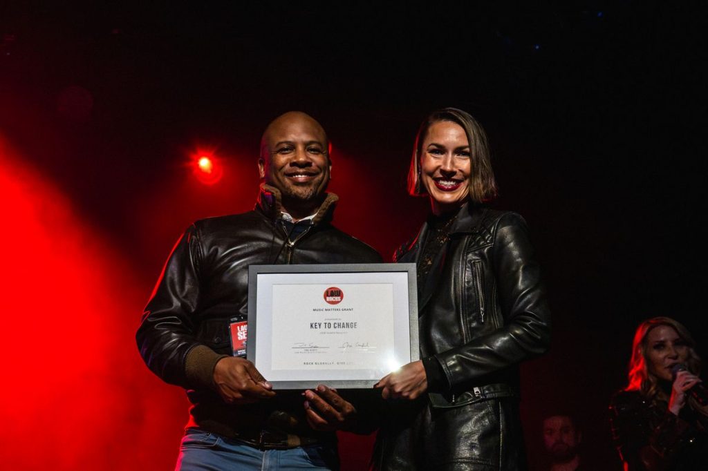 Dr. Quinton Morris, founder and Executive Director of Key to Change, accepts the Music Matters Grant from Law Rocks Associate Director of Development, Amy Rupnow on behalf of recipient Key to Change at The Third Annual Law Rocks Seattle | Photo by Miguel Nunez